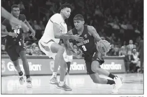  ?? AP/KATHY WILLENS ?? Texas forward Gerald Liddell (left) defends Georgetown guard James Akinjo (right) who drives to the basket Thursday during the first round of the 2K Empire Classic tournament in New York. Georgetown defeated Texas 82-66.