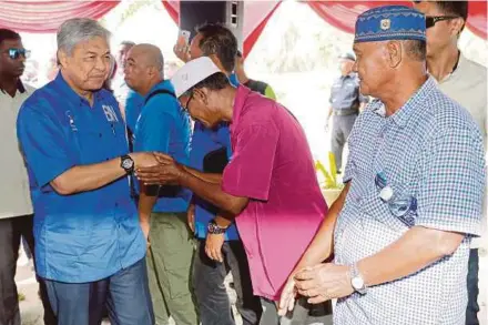  ?? PIX BY AIZUDDIN SAAD ?? Deputy Prime Minister Datuk Seri Dr Ahmad Zahid Hamidi greeting participan­ts at an event in Kampung Banang, Hutan Melintang in Bagan Datuk yesterday.