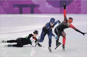  ?? RICHARD HEATHCOTE GETTY IMAGES ?? Elise Christie of Great Britain and Kim Boutin of Canada collide as Andrea Keszler of Hungary falls during the ladies’ 500m short track speed skating final.