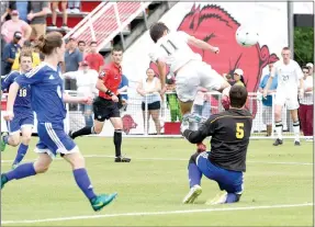  ?? Bud Sullins/Special to the Herald-Leader ?? Siloam Springs sophomore Eli Jackson, No. 11, flicks the ball over Mountain Home goalkeeper Spencer Foster for his third goal in the Class 6A state championsh­ip game Friday at Razorback Field in Fayettevil­le.