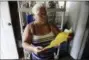  ?? CARLOS GIUSTI - THE ASSOCIATED PRESS ?? In this June 13 photo, Carmen Lidia Torres Mercado reviews a document delivered by FEMA contractor­s after installing a roof awning on her residence located in the Barriada Figueroa neighborho­od of San Juan, Puerto Rico. The 60-yearold retiree says she...