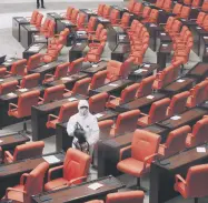  ??  ?? A worker wearing protective gear disinfects the General Assembly of the Turkish Parliament in Ankara, Turkey, Nov. 24, 2020.