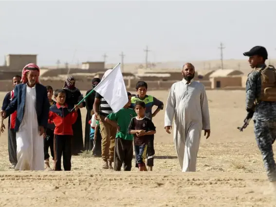  ??  ?? Displaced Iraqis carry a white flag as they approach security forces near Mosul (Getty)