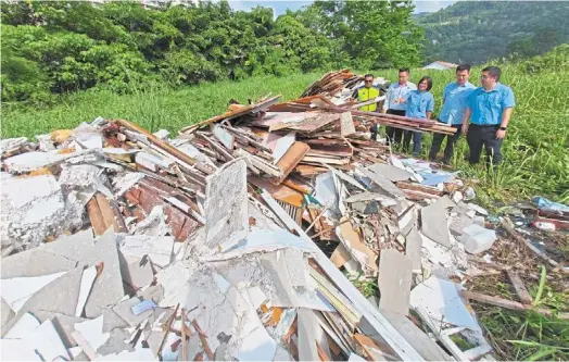  ?? — KT GOH/ The Star ?? Distastefu­l disposal: (From left) rohaizat, ang, Tan, Choong and Theng examining the illegally dumped constructi­on debris in Bukit Jambul.