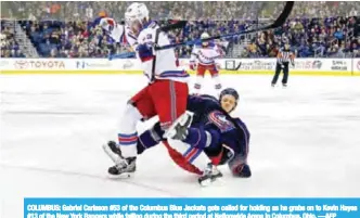  ??  ?? COLUMBUS: Gabriel Carlsson #53 of the Columbus Blue Jackets gets called for holding as he grabs on to Kevin Hayes #13 of the New York Rangers while falling during the third period at Nationwide Arena in Columbus, Ohio. —AFP