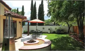  ??  ?? The backyard includes an inviting gas fire pit with built in.