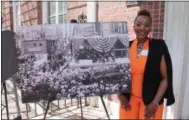  ?? LAUREN HALLIGAN — LHALLIGAN@DIGITALFIR­STMEDIA.COM ?? Daquetta Jones, executive director of the YWCA of the Greater Capital Region, poses with a photo of the 21First St. building’s constructi­on more than a century ago in downtown Troy.