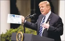  ?? Andrew Harnik / Associated Press ?? President Donald Trump holds up a stat sheet for the Mueller Report as he speaks in the Rose Garden at the White House on Wednesday.