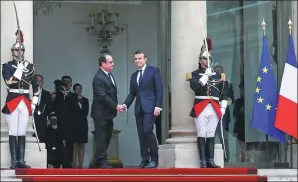  ?? THIBAULT CAMUS / ASSOCIATED PRESS ?? Outgoing French President Francois Hollande (center left) welcomes Emmanuel Macron as he arrives for his inaugurati­on ceremony at the Elysee palace in Paris, France, on Sunday.