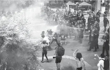  ??  ?? Police use tear gas to break up protesters gathered outside of the Phoenix, Arizona Convention Centre where Trump spoke. — AFP photo