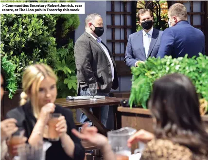  ??  ?? > Communitie­s Secretary Robert Jenrick, rear centre, at The Lion pub in Treorchy this week