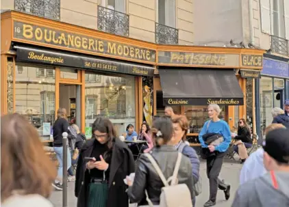  ?? AP PHOTOS/ THIBAULT CAMUS ?? People walk past the “Modern bakery,” Place de d'Estrapade, on Wednesday in Paris. The immense success of the Netflix series “Emily in Paris” has transforme­d a quiet, untouched square in the French capital into a tourist magnet.