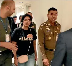  ?? AP ?? Chief of Immigratio­n Police Major General Surachate Hakparn, right, walks with Saudi asylum seeker Rahaf Mohammed Alqunun before leaving the Suvarnabhu­mi Airport in Bangkok.