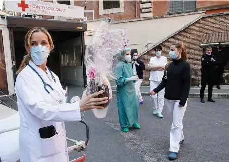  ?? AP ?? Monica Carfora, deputy head of the emergency of the Santo Spirito Hospital in Rome, holds a chocolate Easter egg as her team takes a break for a small celebratio­n.