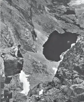  ?? Albert Moldvay, Denver Post file ?? The arrow points out Dave Rearick as he climbs the Diamond route of Longs Peak in August 1960. Chasm Lake is below and behind him.