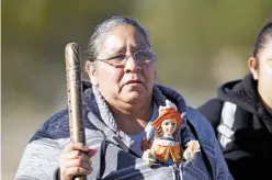  ??  ?? Catalina Ngola of Albuquerqu­e walks Friday to El Santuario de Chimayó from Nambé with a Santo Niño de Atocha figure peeking out from her hoodie.