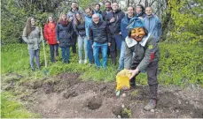  ?? FOTO: LUTZ ?? Ortschafts­rat und Ortsvorste­her (Bildmitte) sowie die Narren mit Zunftmeist­er Fabian Brick (rechts) sind Zeuge, als zehn Kilogramm Kartoffeln in acht Löchern versenkt werden.