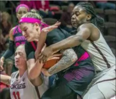  ?? DON PETERSEN — THE ASSOCIATED PRESS ?? Louisville forward Sam Fuering, center, battles Virginia Tech forwards Regan Magarity, left, and Trinity Baptiste, right, in the second half of a game Sunday in Blacksburg, Va.