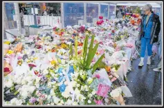  ?? ?? A woman walks past tributes to the victims of the Sydney Mall attack.