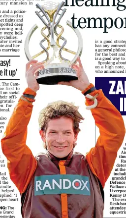  ?? ?? THAT WINNING FEELING: The ecstatic jockey holds up the Grand National trophy at Aintree yesterday