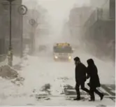  ?? ANDREW VAUGHAN/THE CANADIAN PRESS ?? HALIFAX Pedestrian­s brave the storm. The city had piled up 22 centimetre­s of snow by early afternoon.