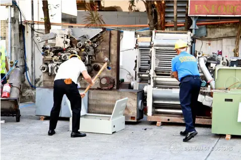  ?? — BOC Photo ?? DESTROYED. Customs officials destroyed and condemned cigarette-making machines yesterday to serve as warning to smugglers and manufactur­ers of fake cigarettes, as part of the activities in the celebratio­n of BOC’s 117th founding anniversar­y.