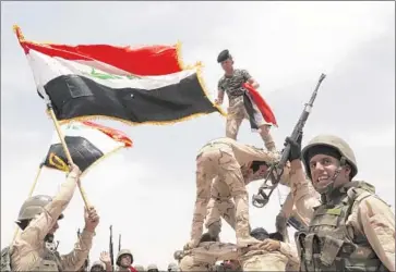  ?? Khalid Mohammed
Associated Press ?? IRAQI TROOPS celebrate during a training mission outside Baghdad last month. An Iraqi lawmaker said the Pentagon’s stringent vetting of recruits has delayed a program to train the Iraqi army to fight Islamic State.