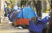  ?? CRAIG MITCHELLDY­ER AP FILE ?? Tents line a sidewalk in Portland, Ore. A record 193 homeless people died in Multnomah County in 2021.