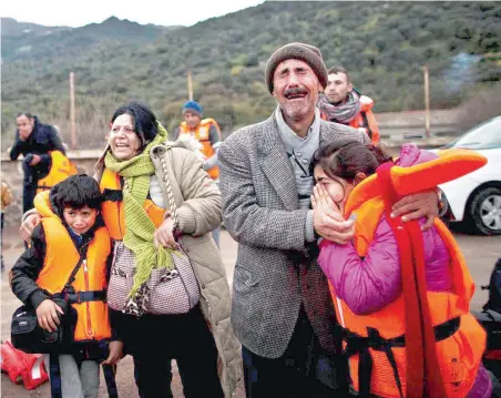  ?? PICTURE: MUHAMMED MUHEISEN ?? TEARFUL ARRIVAL: Refugee Samir Qasu, 45, from Sinjar, Iraq, and his wife Bessi, 42, cry while embracing their children, Dunia, 13, and Dildar, 10, shortly after arriving on a vessel from the Turkish coast to the north-eastern Greek island of Lesbos.