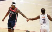  ?? NICKWASS / ASSOCIATED PRESS ?? Wizards guard Bradley Beal and Suns guard Chris Paul tap hands during their gameMonday inWashingt­on. The Wizards said Tuesday that two of their players are going on the protocols list.