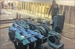  ?? NIKKI SULLIVAN / CAPE BRETON POST ?? Susan Gallop, co-owner of the Cape Breton School of the Arts in Westmount, stands among the equipment being used by Service Master to clean the mess of oil and water left by vandals who broke in and destroyed the place. All walls downstairs have to be...