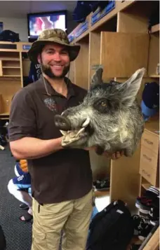  ?? MARC TOPKIN/TAMPA BAY TIMES ?? Rays DH and avid hunter Luke Scott shows off the latest adornment for his locker, the head of the first boar he says he has ever killed with a spear.