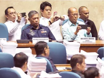  ?? AP FOTO ?? OATH. Defense Secretary Delfin Lorenzana, second from right, and some employees use smartphone­s beside Military Vice Chief of Staff Lt. Gen Salvador Melchor Mison Jr., during the Committee of the Whole session to review the declaratio­n of martial law.