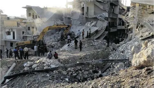  ??  ?? DESPERATE SEARCH: Rescue workers look for survivors after air strikes in the Qefr Teharim town of Idlib, Syria