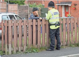  ?? LEON NEAL, GETTY IMAGES ?? A police officer speaks to a neighbor Wednesday near the Manchester home of Salman Abedi.