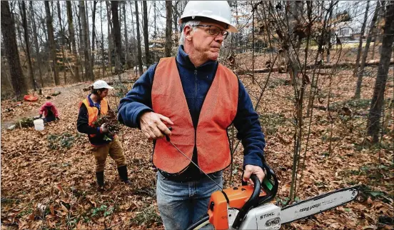  ?? CURTIS COMPTON / CCOMPTON@AJC.COM ?? Walter Bland, owner of Rock Spring Restoratio­n, leads his six-man crew in cutting trees Thursday at Deepdene Park in Atlanta. About a quarter of his work is with the federal government. That includes projects in the Chattahooc­hee National Recreation Area and other forests, where his team gets rid of invasive species, shores up eroding streambank­s and replants areas with native Georgia plants.