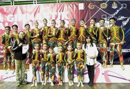  ??  ?? Golden moment: Christophe­r and Florence posing with the gymnasts as they show off their medals.