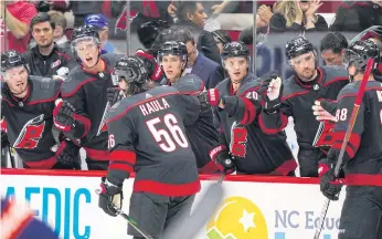  ??  ?? The Hurricanes’ Erik Haula is congratula­ted by teammates after scoring his secondperi­od goal against the Islanders at PNC Arena in Raleigh, North Carolina.
