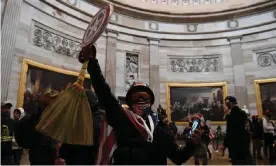  ??  ?? A Donald Trump supporter holds up a Captain America shield in the Capitol’s Rotunda on 6 January. Photograph: Saul Loeb/AFP/Getty Images