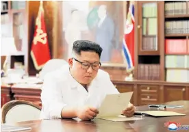  ?? Photo / AP ?? A North Korean Government photo purportedl­y shows Kim Jong Un reading the letter.