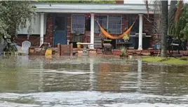  ?? MIKE STOCKER/SOUTH FLORIDA SUN SENTINEL ?? Tropical Storm Nicole’s storm surge floods a front yard Wednesday in Hollywood Beach, Fla., hours before reaching hurricane strength.