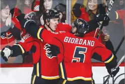  ?? Canadian Press photo ?? Calgary Flames' Mikael Backlund, left, of Sweden, celebrates his game-winning goal with teammate Mark Giordano in overtime NHL hockey action against the Detroit Red Wings in Calgary, Friday.