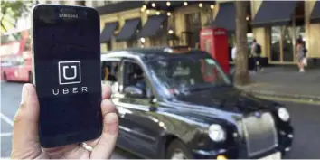  ?? — Reuters ?? A man shows Uber app logo displayed on a mobile phone, as it is held up for a photograph in central London.