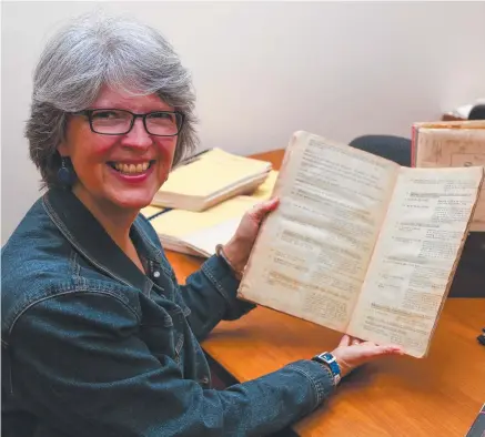  ?? Picture: NQLAA ?? PIECE OF HISTORY: JCU Library special collection­s manager Bronwyn Mcburnie with historical records found in Charters Towers.