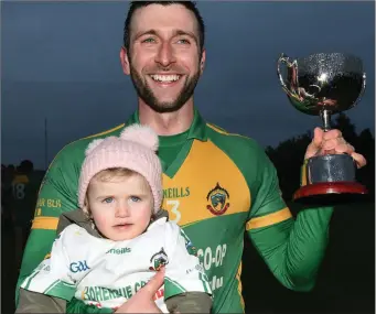  ??  ?? Boherbue captain Conor O’Riordan joined by daughter Lily after receiving the Duhallow Nevin Cup Junior B Football League title