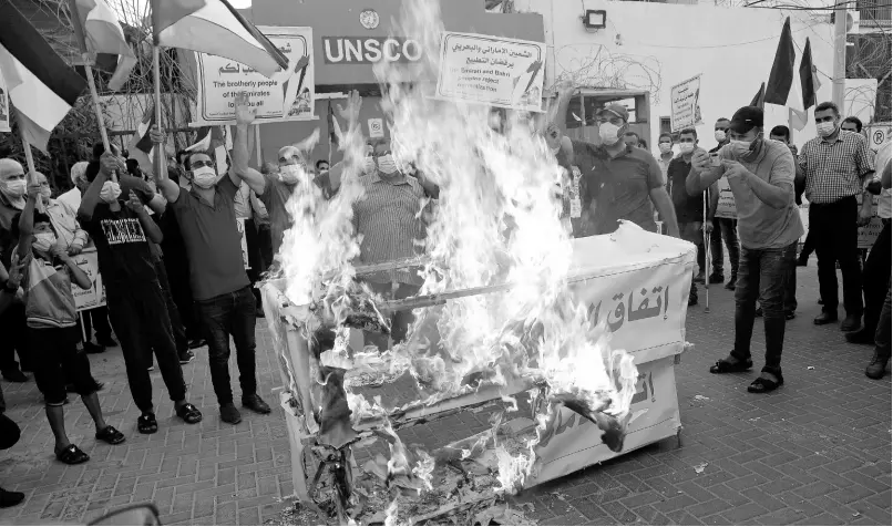  ?? AP ?? Palestinia­ns burn mock coffins representi­ng the United Arab Emirates and Bahraini normalisat­ion agreements with Israel. This is during a protest in front of the office of the United Nations Special Coordinato­r for the Middle East Peace Process in Gaza City on Tuesday.