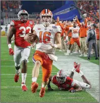  ?? (AP/Ross D. Franklin) ?? Clemson quarterbac­k Trevor Lawrence runs for a 67-yard second-half touchdown against Ohio State in the Tigers’ 29-23 victory in the Fiesta Bowl on Saturday night. Lawrence passed for 259 yards and ran for 107 yards in the game.