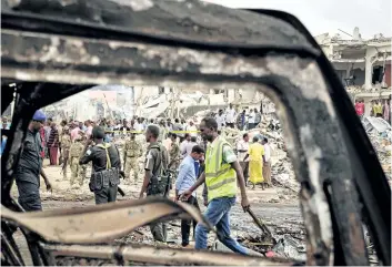  ?? MOHAMED ABDIWAHAB/GETTY IMAGES ?? Somali soldiers patrol on the scene of an explosion in the centre of Mogadishu, on Sunday. A truck bomb exploded outside a hotel at a busy junction on Saturday, killing more than 200 people.