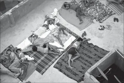  ?? Associated Press ?? Indians sleep on the roof of a house to beat the heat Friday in New Delhi, India. Even for a world getting used to wild weather, May seems stuck on strange. Torrential downpours in Texas, whiplashin­g the region from drought to flooding. A heatwave that...