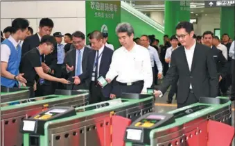  ?? CHINA NEWS SERVICE ?? Pony Ma (right), founder and CEO of Tencent, Liu Qingsheng (second from right), executive vice-mayor of Shenzhen, and other officials and business leaders use WeChat QR code scanning at a subway entrance in Shenzhen on May 8.